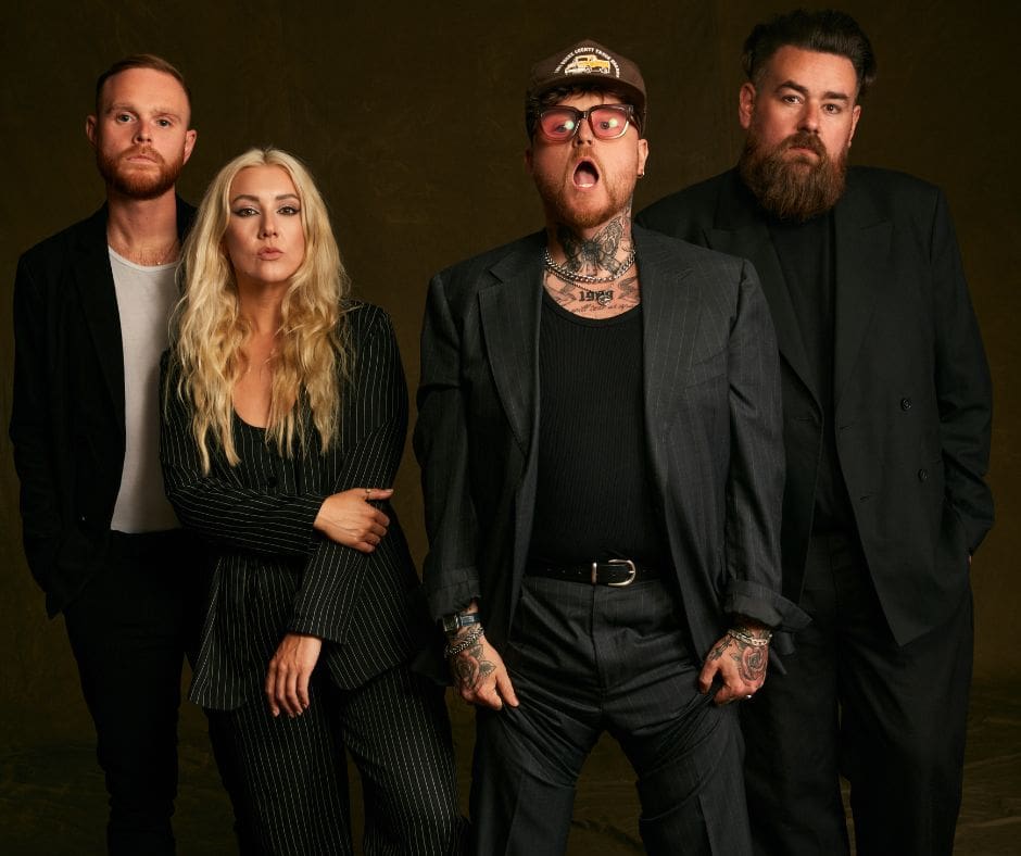 The four members of band Lottery Winners (3 men and one woman) dressed in black against a black background